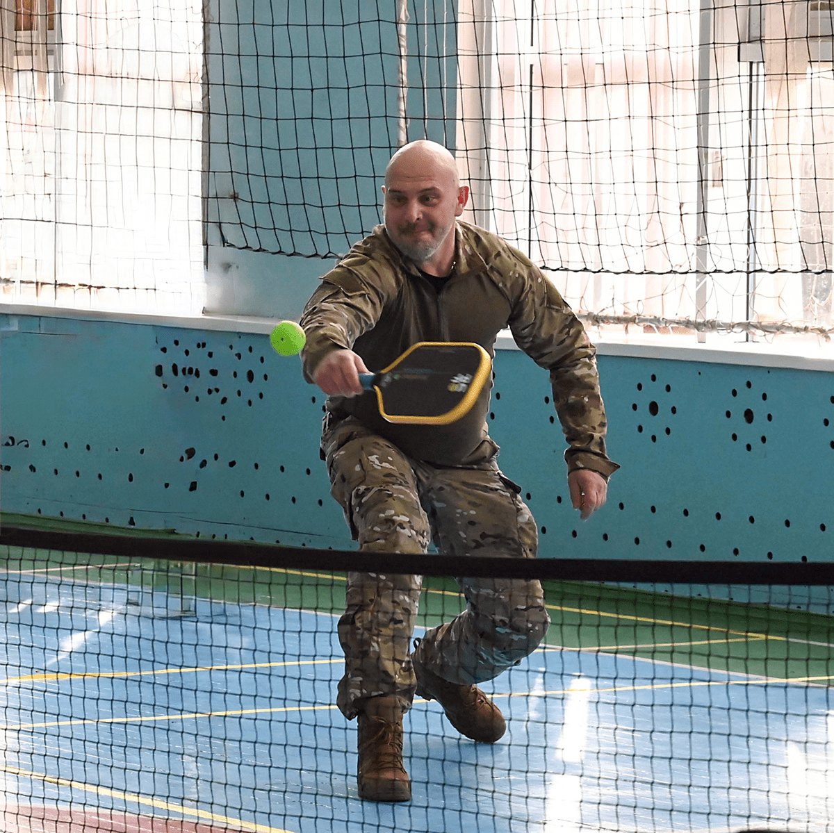 Ukrainian veteran playing pickleball indoors with a Freedom Fighter Paddle.