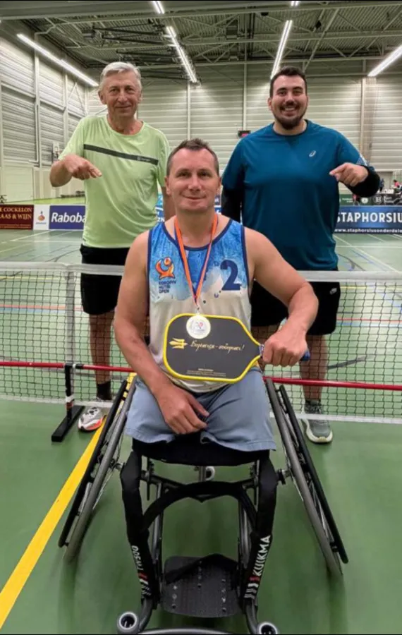 Ukrainian wheelchair player with his medal and Freedom Fighter Paddle at a tournament